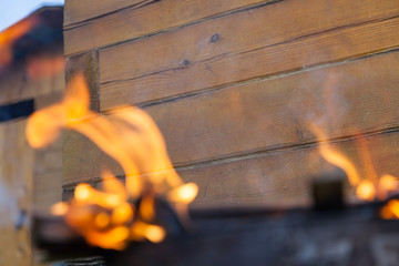 Close-up on a fire during a fire or burning fire on the background of a wooden wall. Work for...