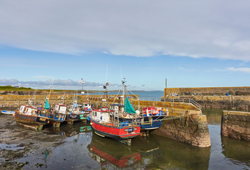 Fototapeta na wymiar The Inner Harbour entrance at Slade Harbour, a small Fishing Village in County Wexford, Southern Ireland, with Fishing Boats lying on the Silt.