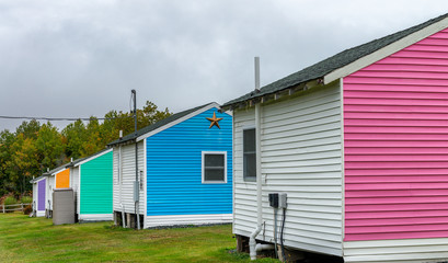 Fototapeta na wymiar Colorful wooden homes on a green background