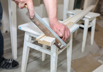 Man is installing the doors. Carpenter sawing wooden plank. Repair works. Maintenance in the apartment.