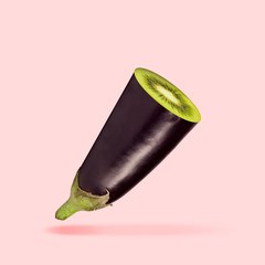 The hidden sense. An eggplant with kiwi inside it on coral background. Unusual combination. Negative space to insert your text. Modern design. Contemporary art. Creative conceptual and colorful