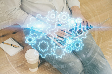 Double exposure of businessman working on laptop on background. International business hologram in front. Concept of success.