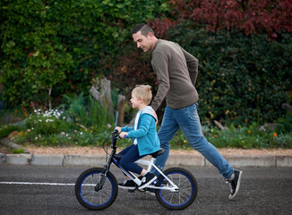 Obraz premium Dad teaching how to ride a bike