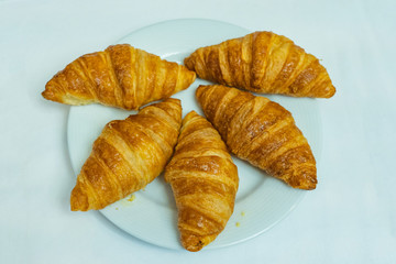 Top view of croissants on white plate and white background