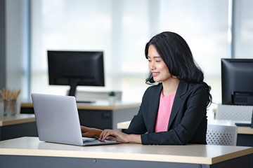 Fototapeta premium Asian businesswoman using laptop in office..