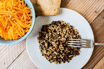 Assiette de grains de millet et couscous et bol de carottes râpées