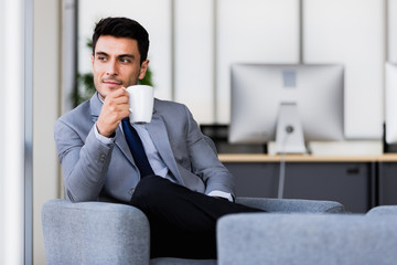 Businessman drinking coffee in office..