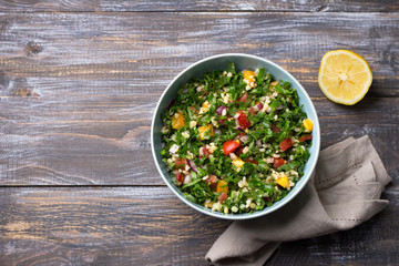Original oriental salad tabbouleh with cabbage kale, parsley, bulgur, tomatoes and red onions on a...
