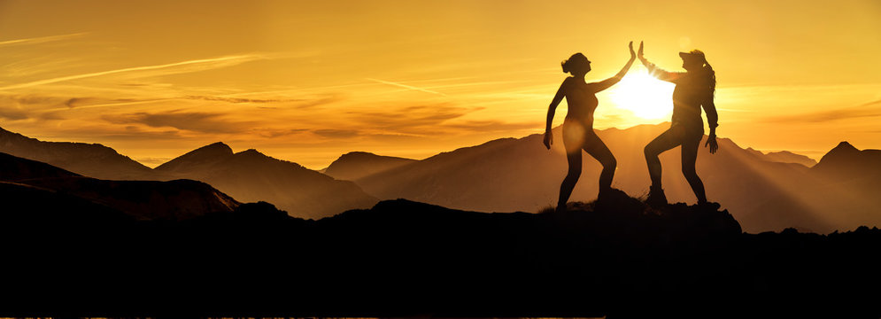 Zwei Frauen beim Abklatschen auf einem Berggipfel