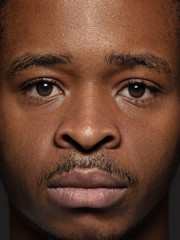 Close up portrait of young and emotional african-american man. Highly detail photoshot of male model with well-kept skin and bright facial expression. Concept of human emotions. Looking at camera.