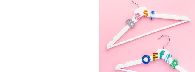 White hangers with sale text on pink background