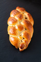 Homemade food concept fresh baked bread braid challah dough on black slate stone with copy space