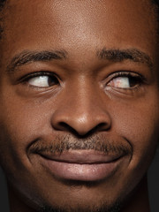 Obraz premium Close up portrait of young and emotional african-american man. Highly detail photoshot of male model with well-kept skin and bright facial expression. Concept of human emotions. Looking at side.