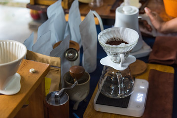 Close up of filter coffee maker, kettle with thermometer and digital scale on wooden table.Barista brewing coffee, method pour over, drip coffee.