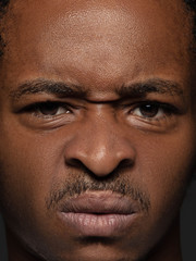 Close up portrait of young and emotional african-american man. Highly detail photoshot of male model with well-kept skin and bright facial expression. Concept of human emotions. Outraged.