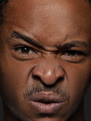Close up portrait of young and emotional african-american man. Highly detail photoshot of male model with well-kept skin and bright facial expression. Concept of human emotions. Outraged.