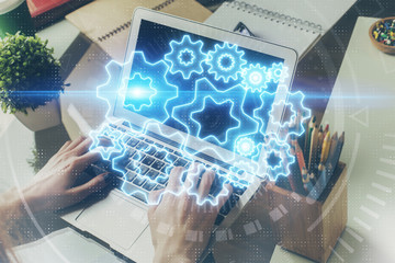 Double exposure of businessman working on laptop on background. International business hologram in front. Concept of success.