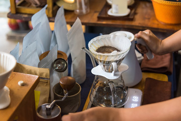Close up of filter coffee maker, kettle with thermometer and digital scale on wooden table.Barista brewing coffee, method pour over, drip coffee.