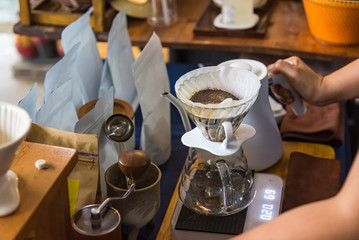 Close up of filter coffee maker, kettle with thermometer and digital scale on wooden table.Barista brewing coffee, method pour over, drip coffee.
