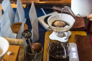 Close up of filter coffee maker, kettle with thermometer and digital scale on wooden table.Barista brewing coffee, method pour over, drip coffee.