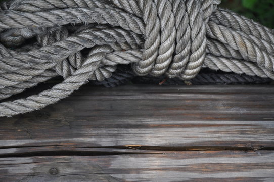 A string of gray rope on old deck boards