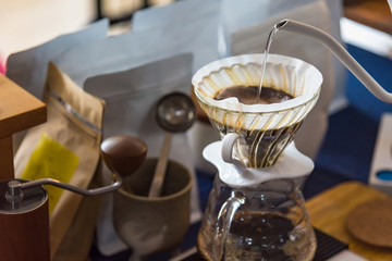Close up of filter coffee maker, kettle with thermometer and digital scale on wooden table.Barista brewing coffee, method pour over, drip coffee.