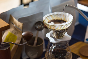 Close up of filter coffee maker, kettle with thermometer and digital scale on wooden table.Barista brewing coffee, method pour over, drip coffee.