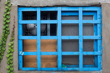 Blue wooden frame window and concrete wall.