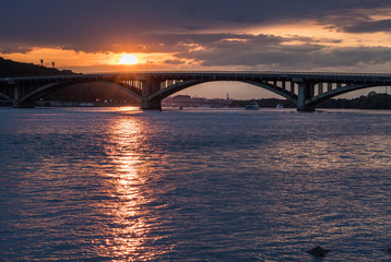 Fototapeta na wymiar Scenic sunset view on a metro bridge and Dneper River from Hydropark in Kyiv, Ukraine
