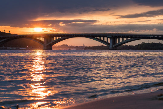 Scenic sunset view on a metro bridge and Dneper River from Hydropark in Kyiv, Ukraine