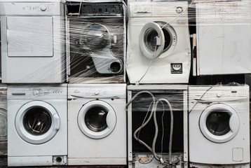 Old broken washing machines being colleted as electronic waste for recycling