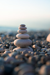 pyramid of pebbles on the beach sea. illuminated by the sun.