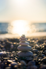 pyramid of pebbles on the beach sea. illuminated by the sun.