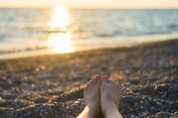 feet against the sea at sunset