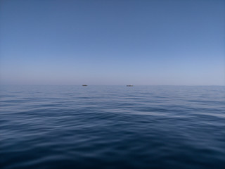 Beautiful calm adriatic blue sea with small reefs and signalization light.