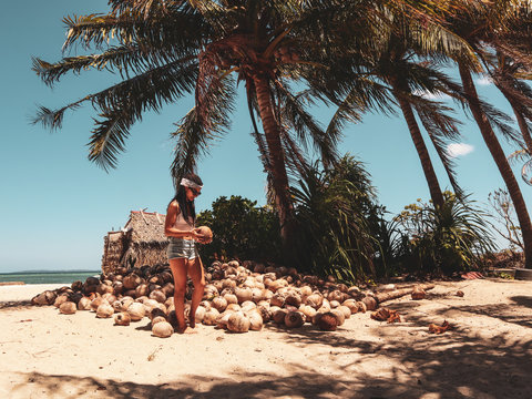 Woman holding coconut shells in the palm tree jungle in Onok island in Balabac Palawan in Philippines