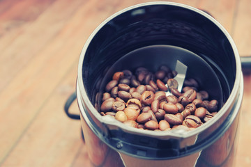 Coffee grains in a black electric coffee grinder