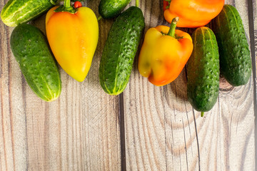 Fresh cucumbers and sweet peppers on a wooden table. Autumn harvest thanksgiving Day.