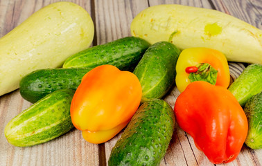 Fresh cucumbers, courgettes and sweet peppers on a wooden table. Autumn harvest thanksgiving Day.