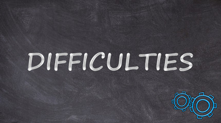 Obraz premium Difficulties written on blackboard with rotating toothed wheels