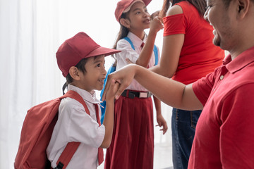 student kiss his parent's hand before going to school. salim indonesian tradition
