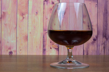 Brandy in a glass snifter on a wooden table