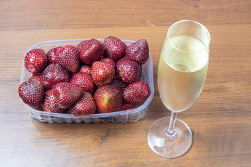 Champagne with strawberries on a wooden table