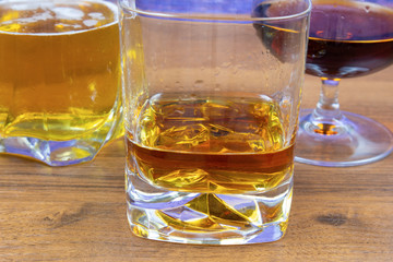 Three glasses with different colored alcoholic drinks