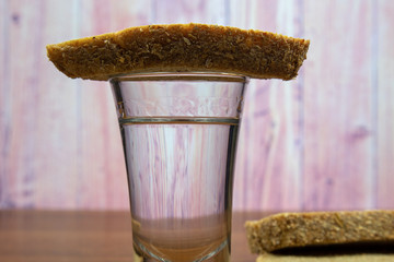 A glass of vodka covered with a slice of black bread