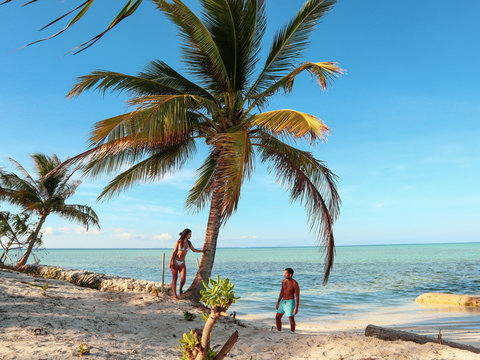 Lovely couple standing near palm trees in paradise Onok Island in Balabac Palawan in Philippines