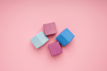 Colorful wooden cubes on pink background.Creativity toys. Children's building blocks