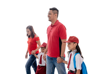 asian parent walk their children to school for the first time after a long holiday