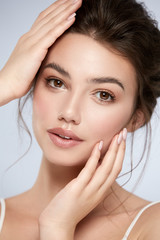 Naklejka premium beautiful woman with perfect make-up and big lips touching her face