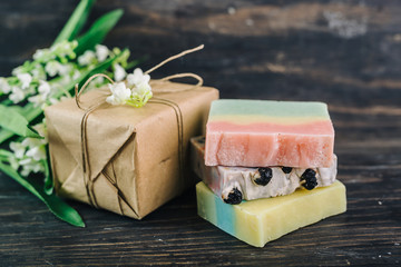 colorful handmade soaps and gift box on dark wooden background